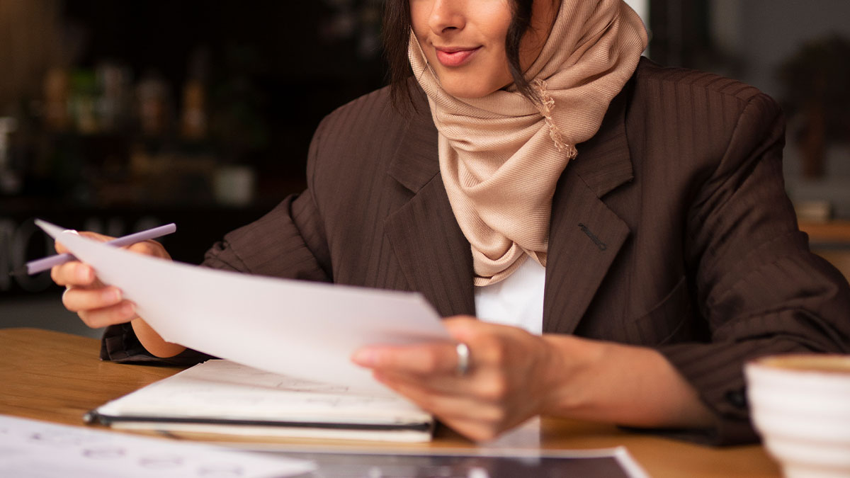 Professional woman reviewing investment portfolio with Dubai skyline background - wealth management for women in UAE